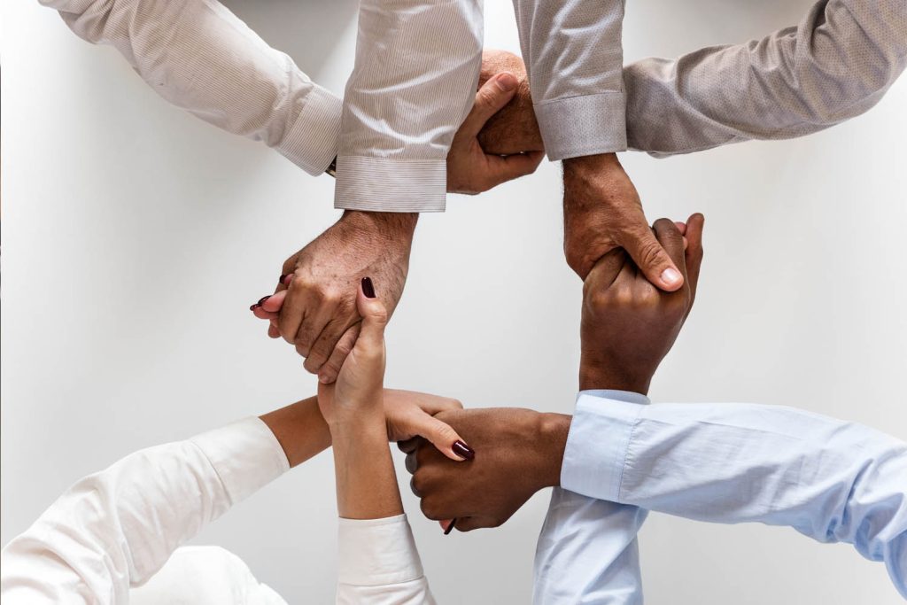mãos de colaboradores unidas mostrando o que é cultura organizacional